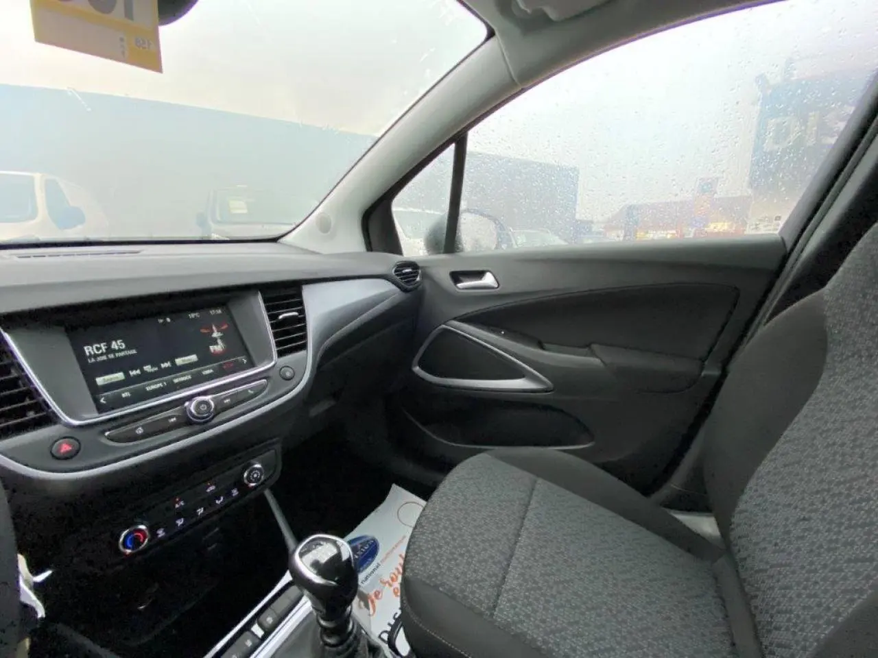 Vue intérieure côté passager de l’Opel Crossland gris, avec tableau de bord et écran tactile multimédia visible.