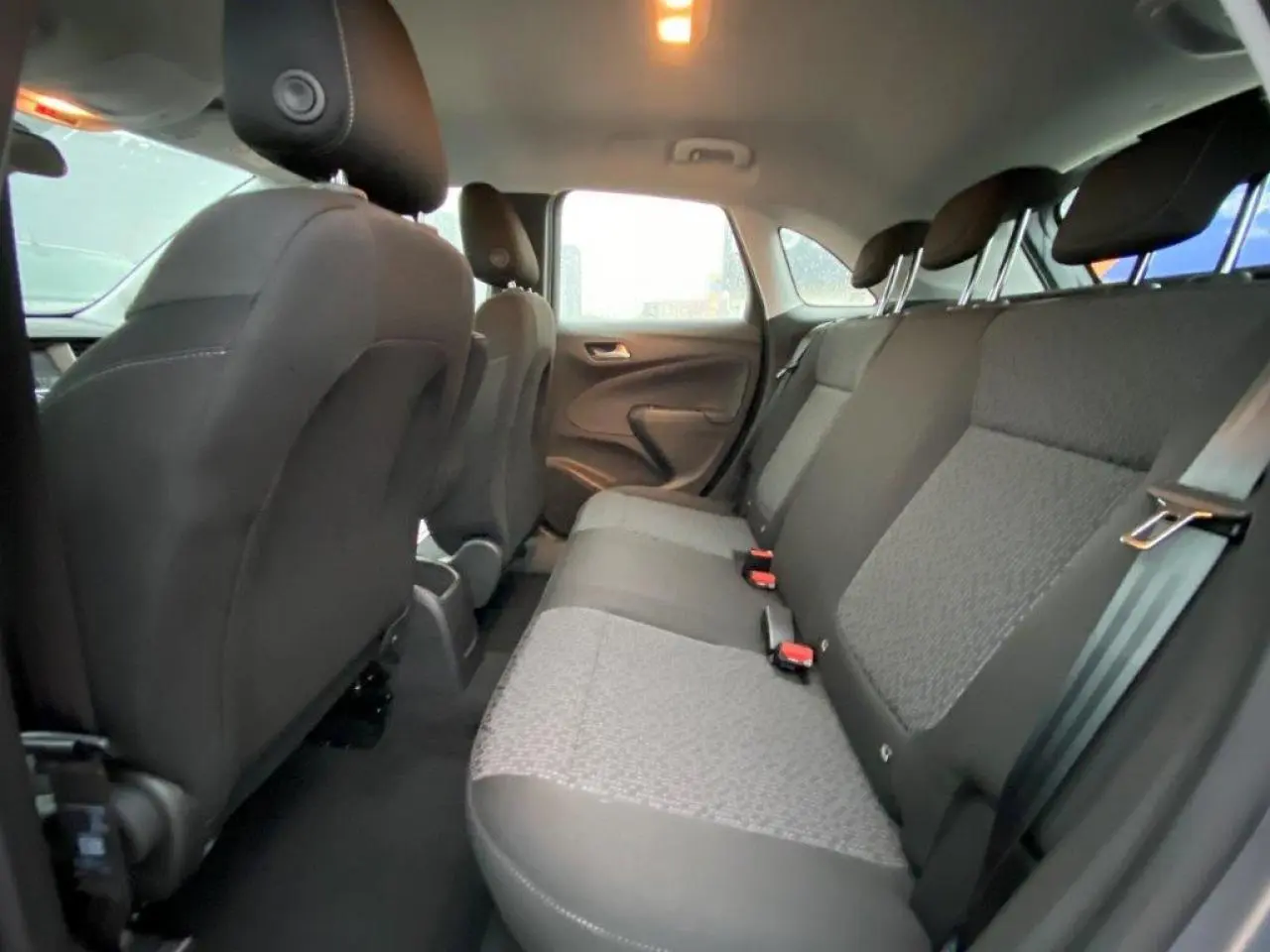 Vue intérieure arrière de l’Opel Crossland 2022, montrant les sièges arrière en tissu gris et noir.