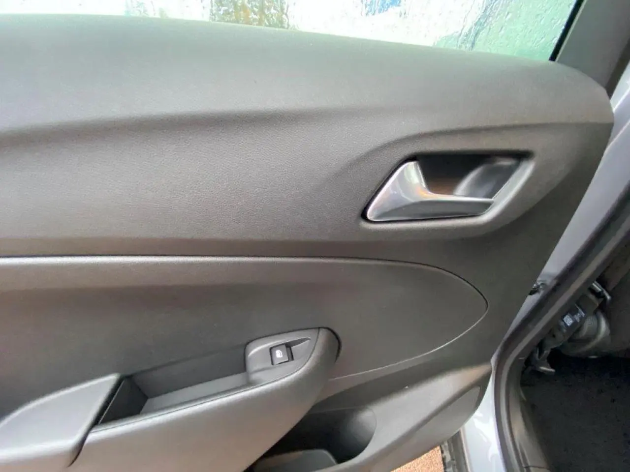 Vue rapprochée de la porte avant droite grise métallisée de l’Opel Crossland 2022 avec poignée et bouton de verrouillage.