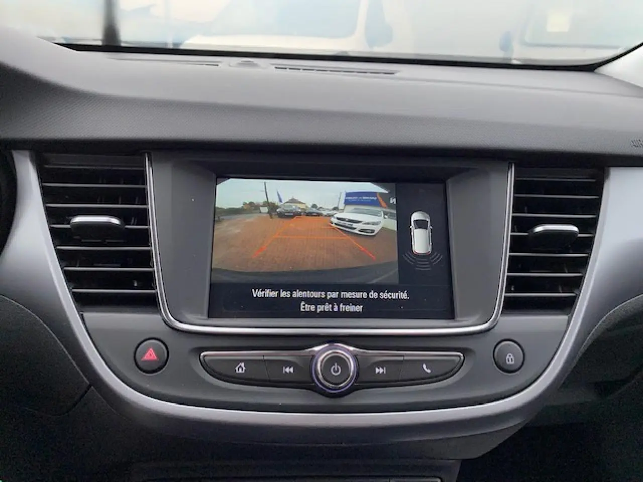 Vue rapprochée de l’écran tactile central affichant la caméra de recul de l’Opel Crossland gris métallisé.