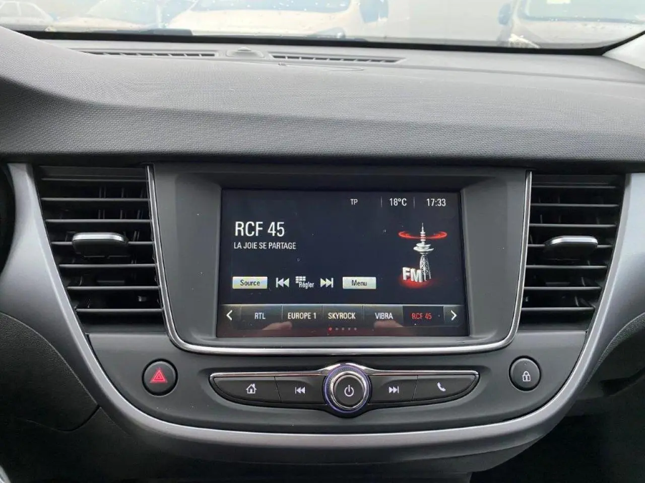 Vue rapprochée du tableau de bord de l’Opel Crossland 2022, écran tactile multimédia avec radio FM affichée.
