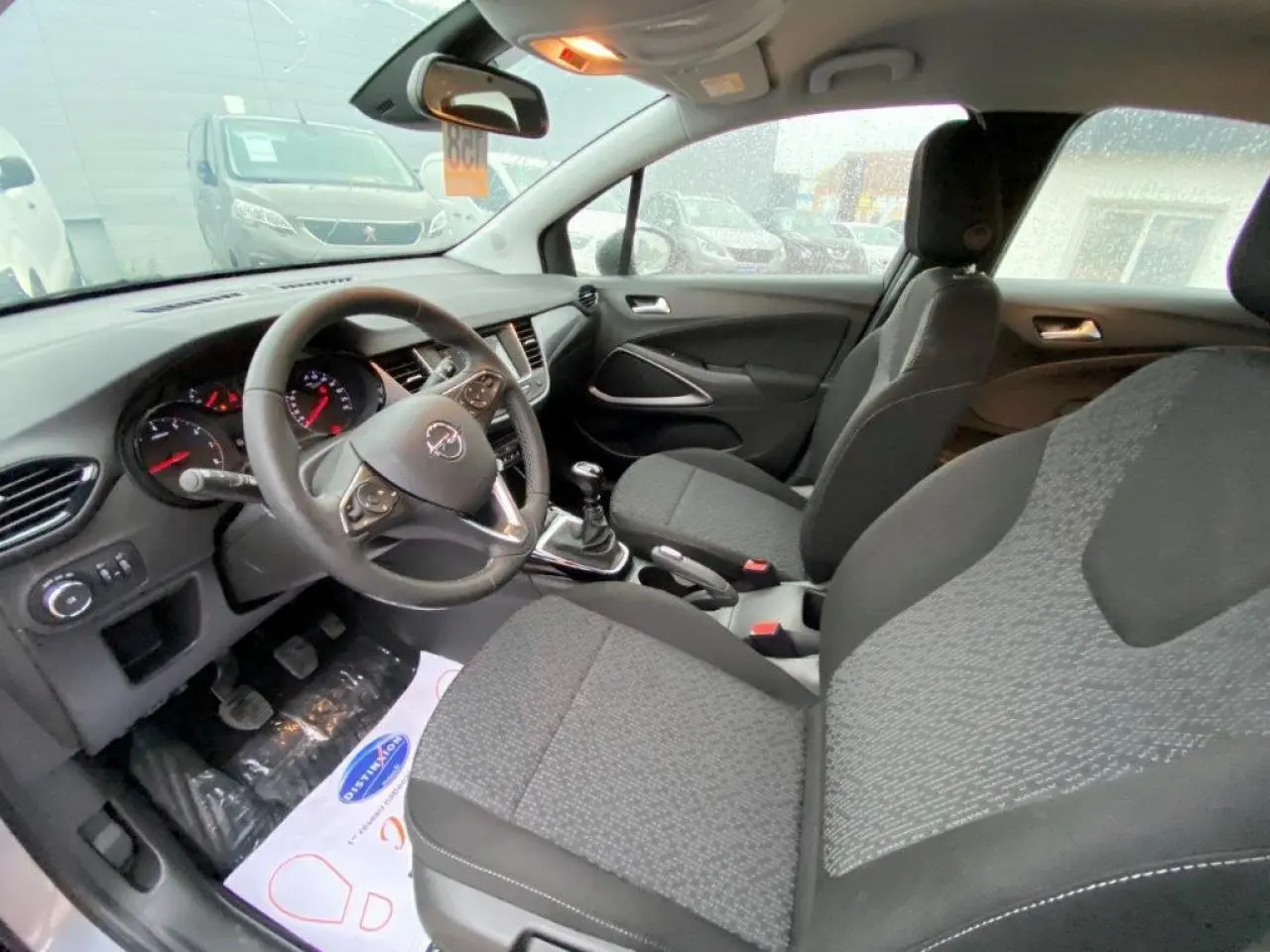 Intérieur d’Opel Crossland gris métallisé vu côté conducteur, volant cuir multifonction et boîte manuelle visibles.