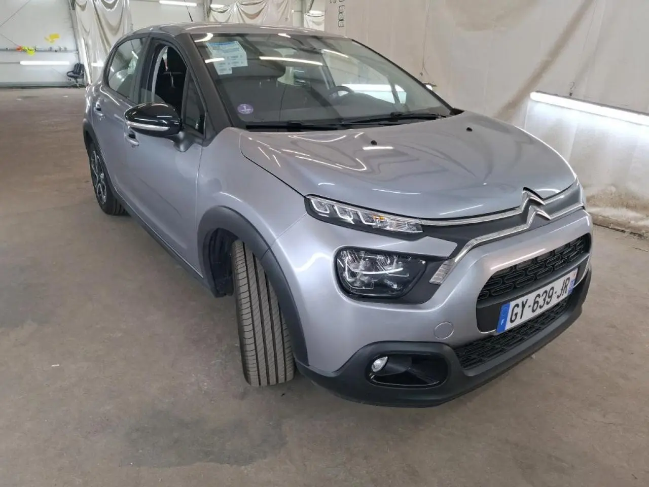 Citroën C3 gris foncé vue 3/4 avant droit, avec phares LED et calandre noire distinctive.