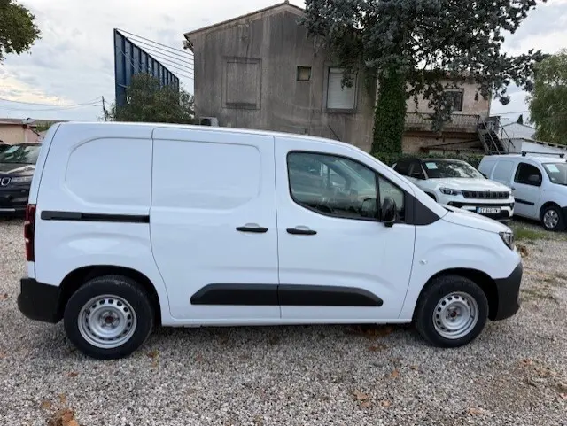 Vue de profil droit d’un Citroën Berlingo blanc version Van M Diesel 100 ch, avec portes coulissantes et jantes acier.