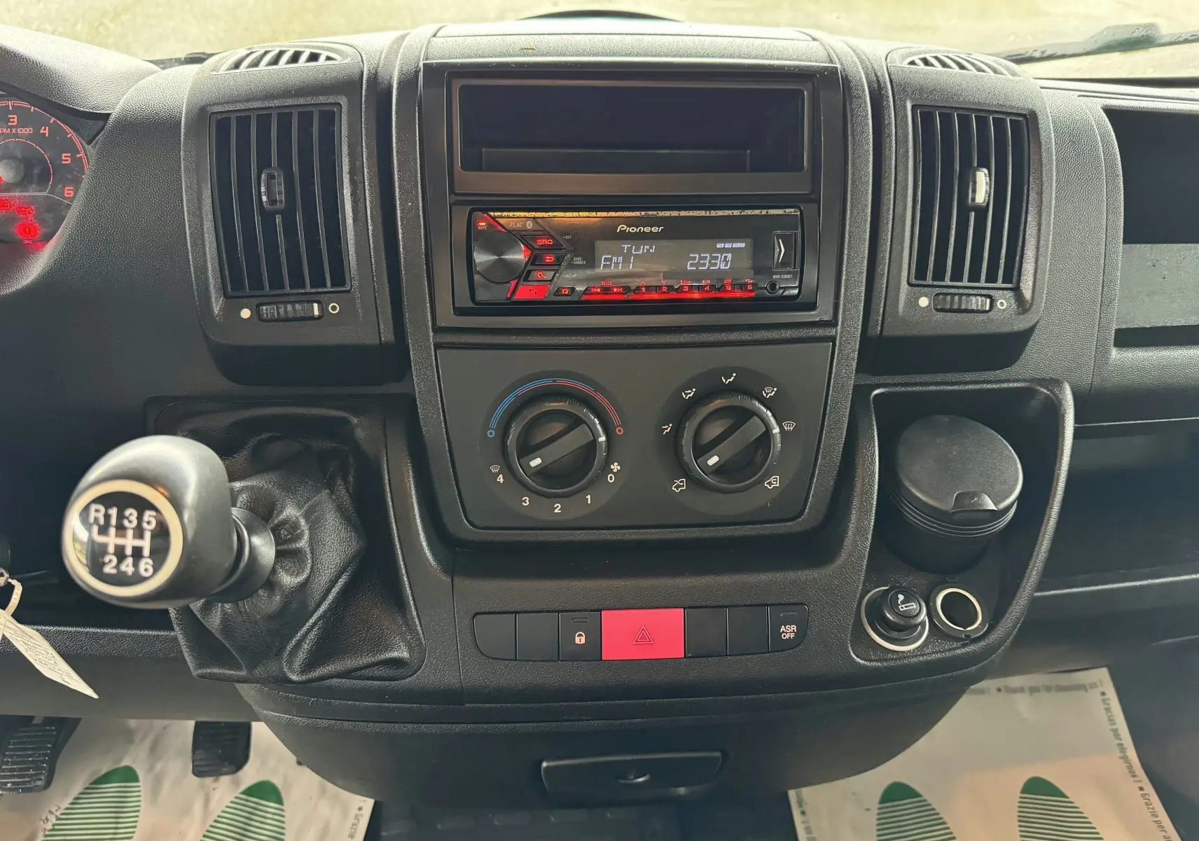 Tableau de bord noir du Citroën Jumper Benne 2019 avec radio Pioneer, commandes clim, et levier de vitesse manuel visible.