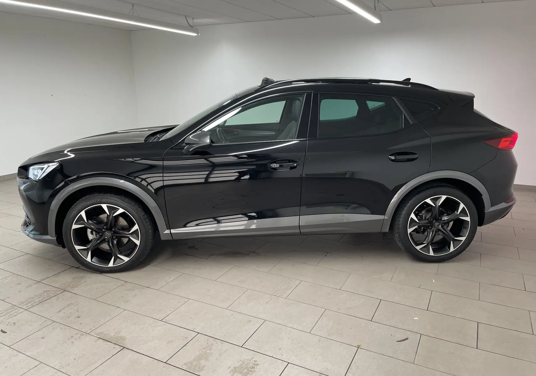 Vue latérale gauche d'un CUPRA Formentor 1.5 TSI 150 DSG7 VZ-LINE noir minuit avec jantes alliage distinctives.