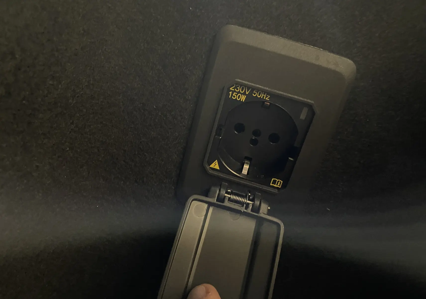 Prise électrique 230V 150W intégrée dans le coffre d'un CUPRA Formentor Noir Minuit 2023, détail intérieur.