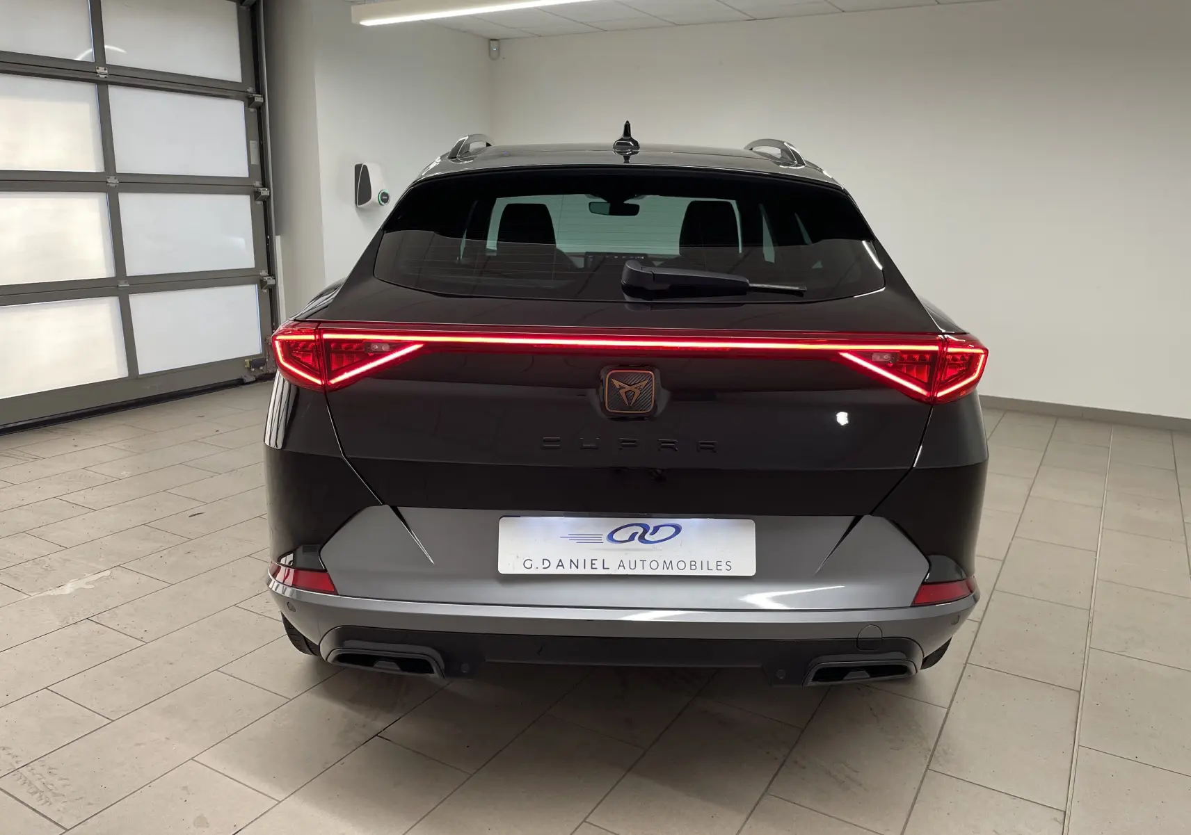 Vue arrière du CUPRA Formentor 2023 en noir minuit avec feux LED en forme de flèche et double sortie d'échappement.