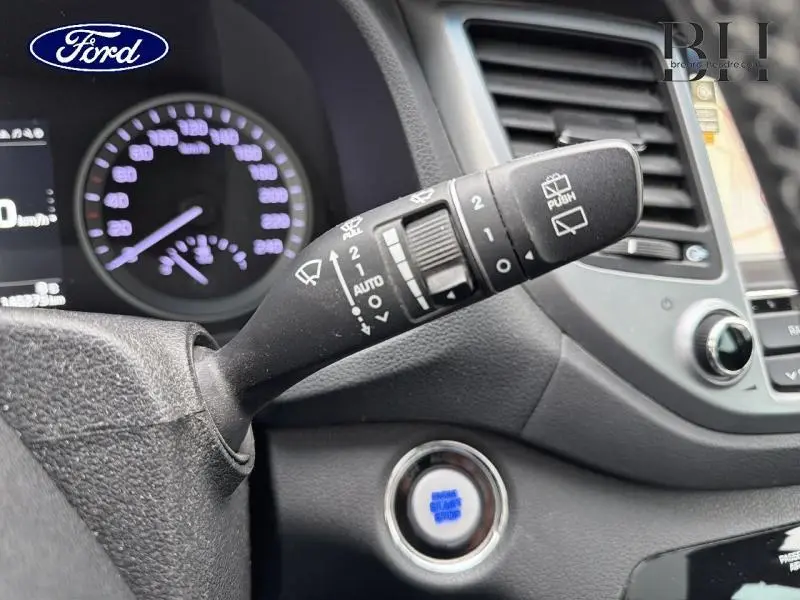 Levier de commande d’essuie-glace en gros plan dans l’habitacle d’un Hyundai Tucson Phantom Black, avec tableau de bord et bouton start visible.