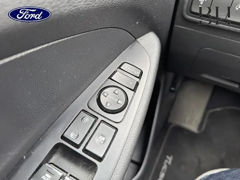 Détail des commandes de réglage des rétroviseurs et des vitres côté conducteur d'un Hyundai Tucson Phantom Black, intérieur noir.