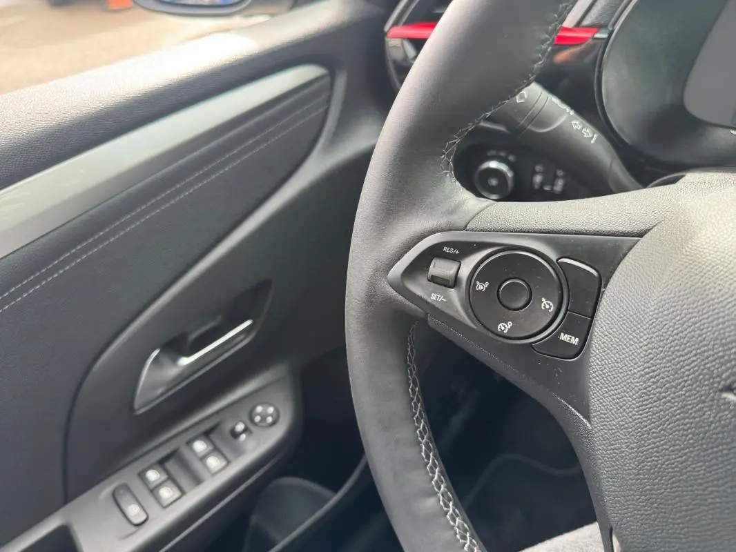 Gros plan sur le volant et la portière côté gauche de l’Opel Corsa gris clair 2022, version GS Line.