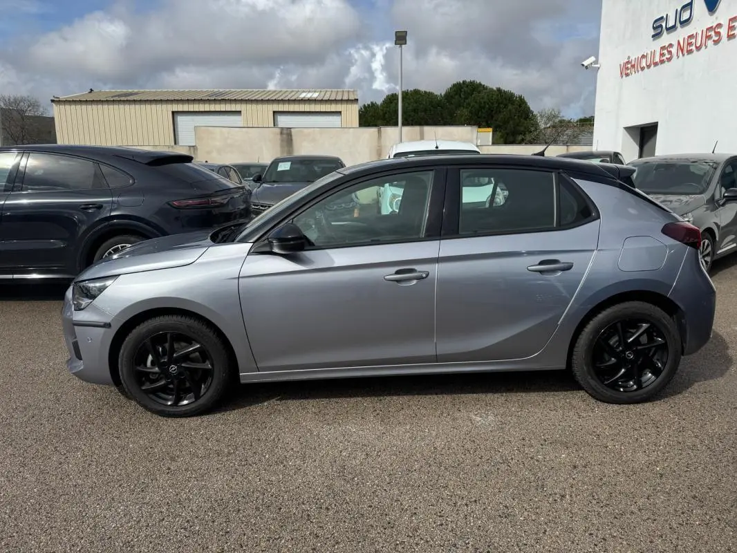 Opel Corsa 1.2 Turbo 2022 gris clair vue de profil côté gauche avec jantes noires et toit noir contrasté.