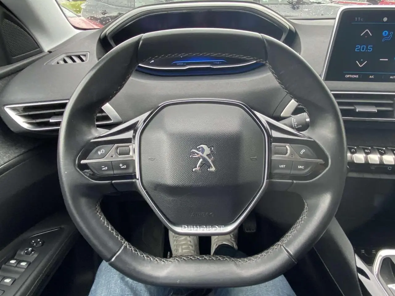 Vue intérieure centrée sur le volant compact noir du Peugeot 3008 avec tableau de bord numérique et écran tactile.