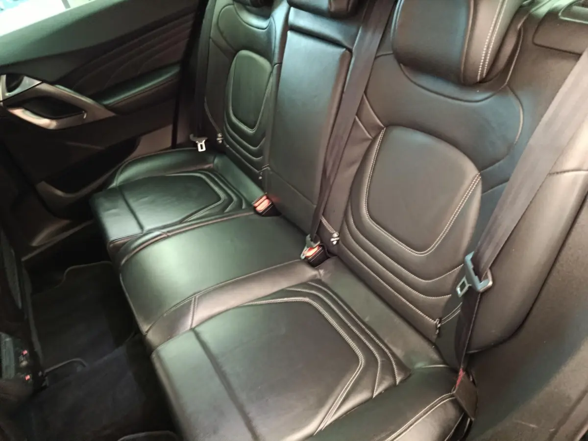 Vue intérieure des sièges arrière en cuir noir de la DS5 BlueHDi 180 Chic, avec surpiqûres apparentes et ceinture de sécurité.