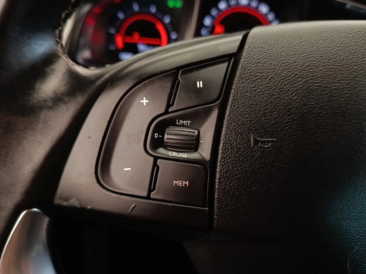 Gros plan sur les commandes de régulateur de vitesse du volant en cuir noir du DS5 BlueHDi 180 Automatique Chic.