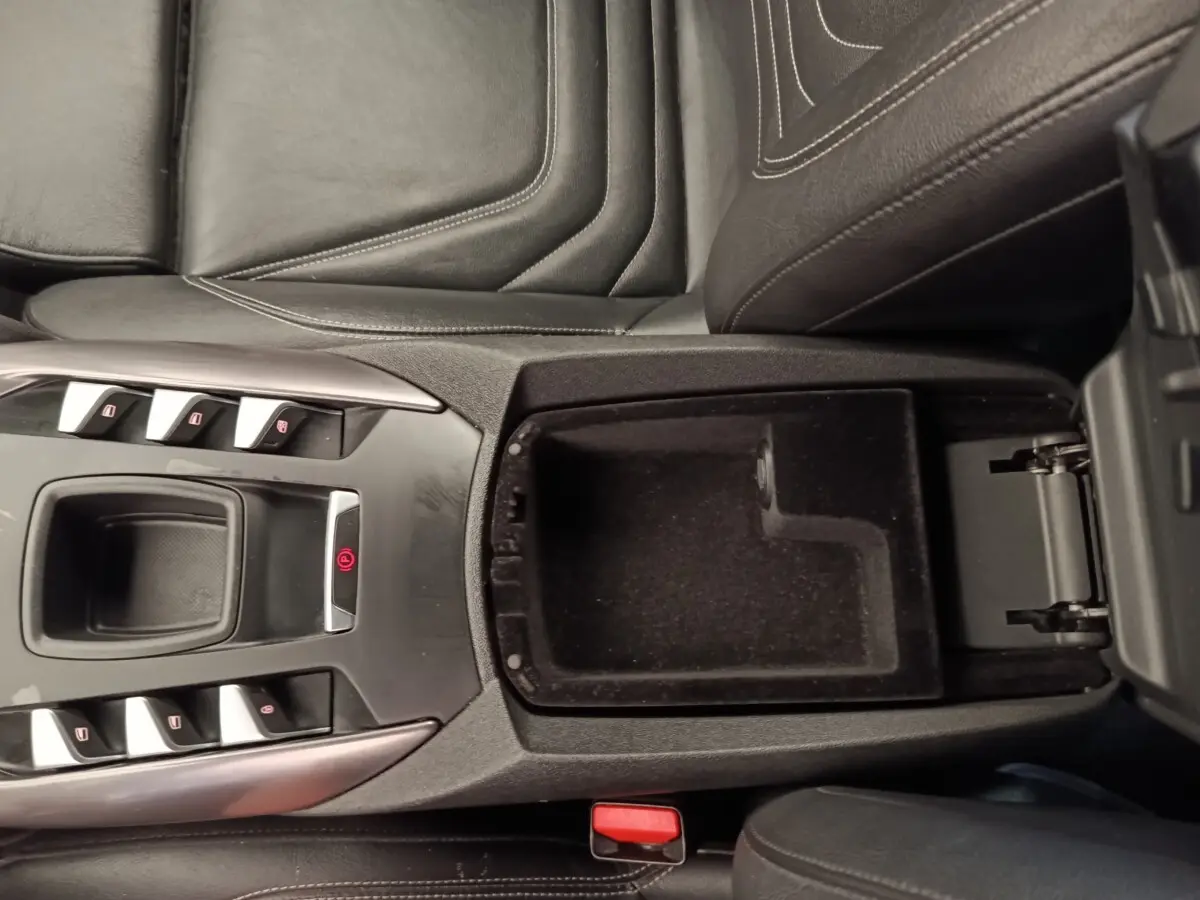 Vue plongeante sur la console centrale noire du DS5 2018, avec accoudoir ouvert et commandes électriques visibles.