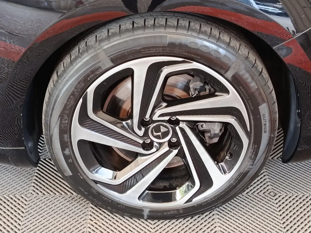Gros plan sur la roue avant gauche noire d'une DS5 2018, jante alliage bicolore au design moderne.