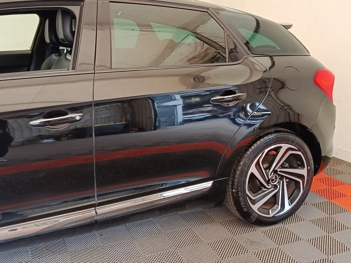 Vue latérale droite d'une DS5 noire 2018, mettant en valeur la jante alliage et les poignées chromées.