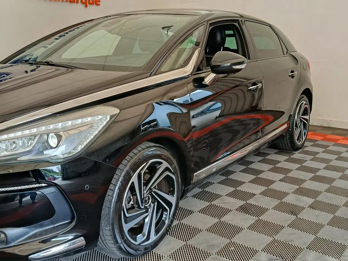 Vue 3/4 avant droit d'une DS5 noire brillante avec jantes alliage distinctives et rétroviseurs ton caisse électriques.