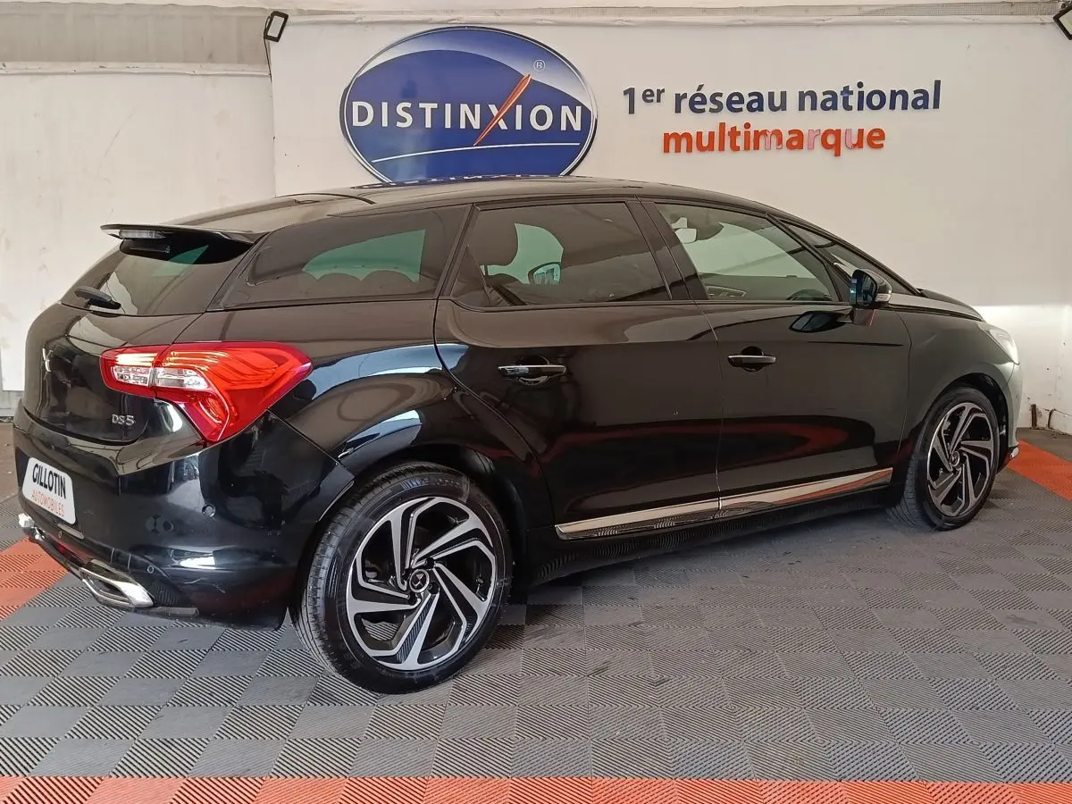 DS5 noir vue 3/4 arrière droit, jantes alliage distinctives et feux arrière LED visibles en intérieur showroom.