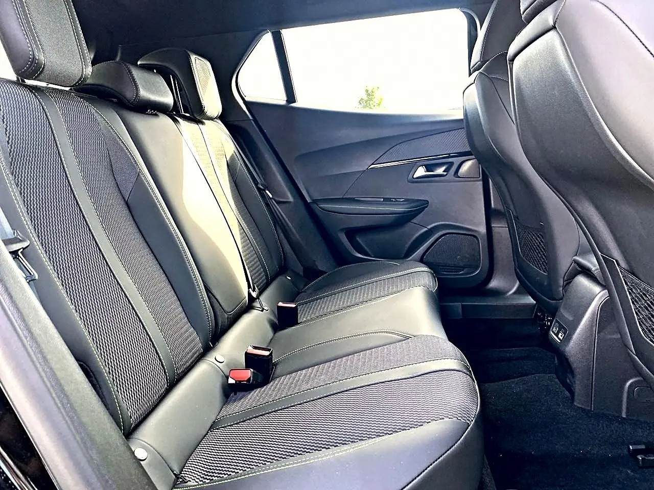 Vue intérieure côté droit des sièges arrière en tissu noir et cuir du Peugeot 2008 1.2 hybrid 145 GT 2025.