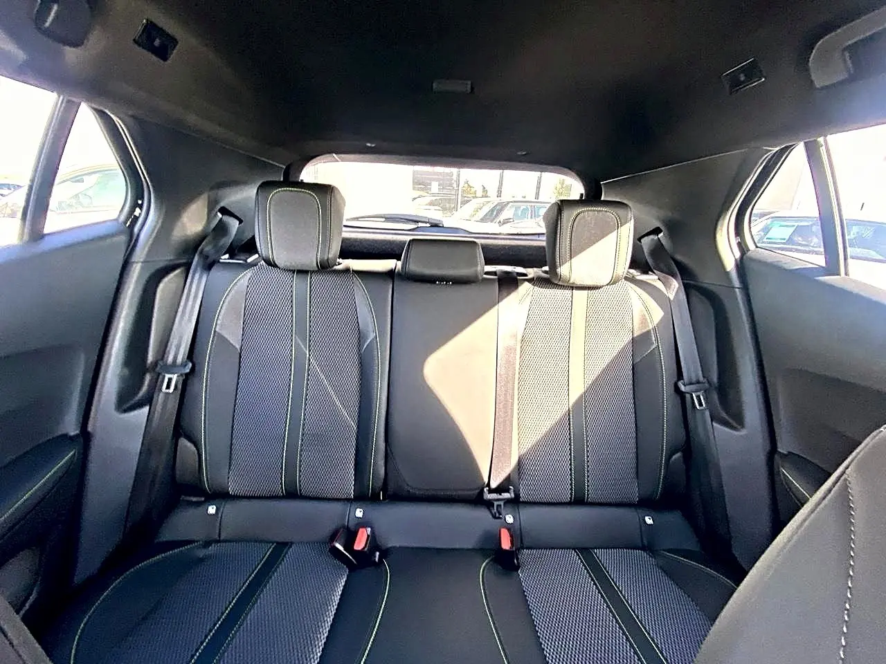 Vue arrière intérieure sur la banquette arrière noire avec surpiqûres claires du Peugeot 2008 1.2 hybrid 145 GT.