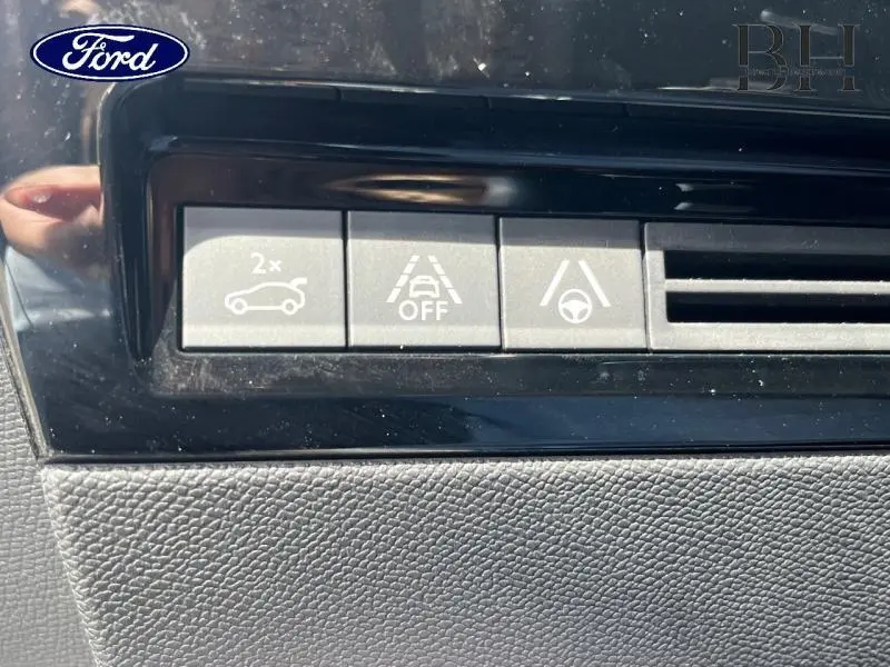 Gros plan sur les boutons de commande d'assistance à la conduite dans un intérieur noir, sans lien visible avec Peugeot 508 SW.
