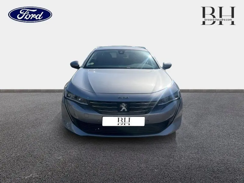 Vue de face d'une Peugeot 508 SW gris Artense avec calandre noire et logo lion central bien visible.