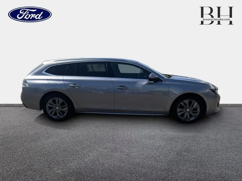 Profil côté gauche d'une Peugeot 508 SW gris Artense 2021 avec jantes alliage et vitres surteintées.