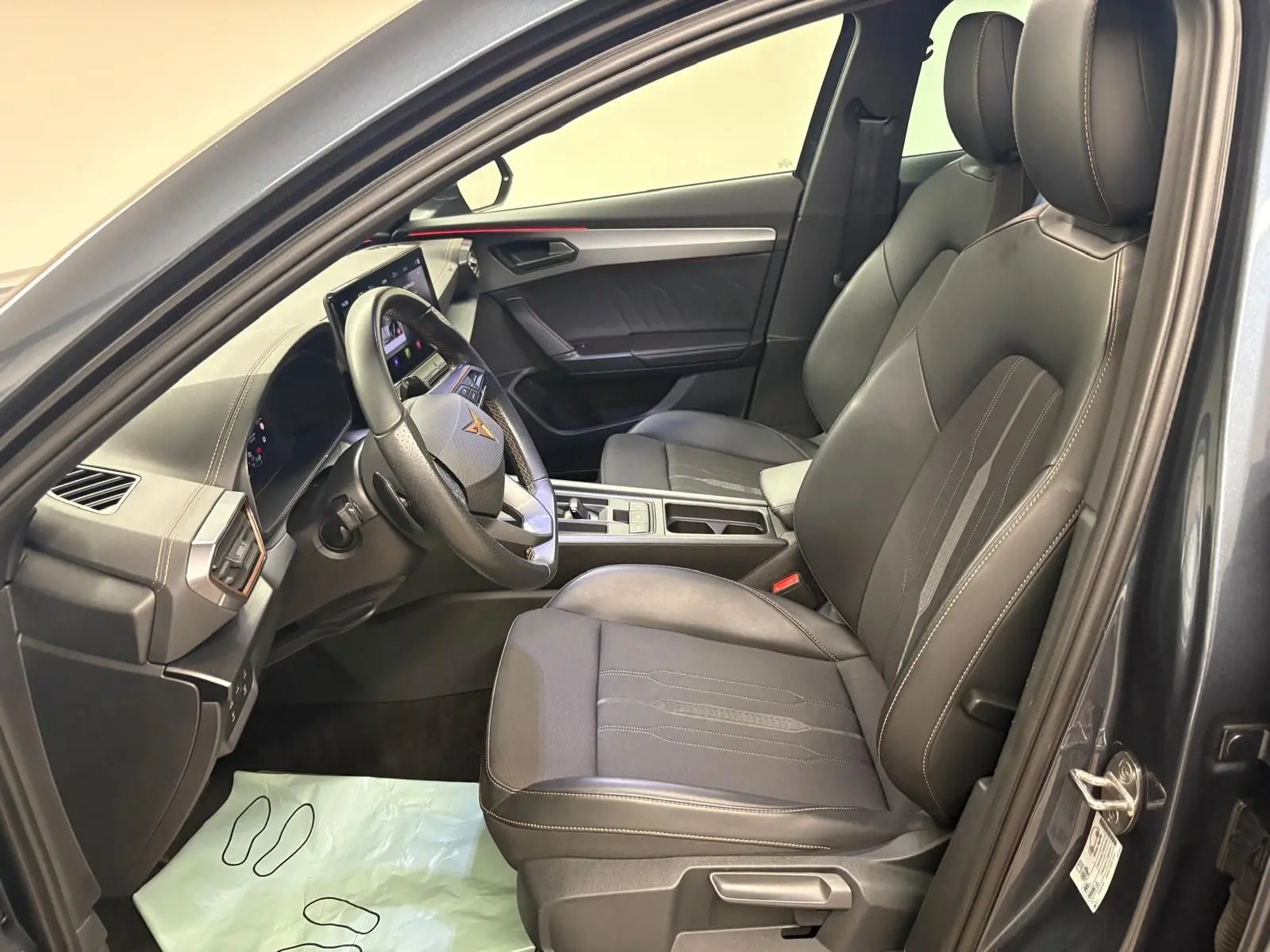 Intérieur côté conducteur du CUPRA Formentor gris magnétique 2023, sièges noirs avec surpiqûres et tableau de bord moderne.
