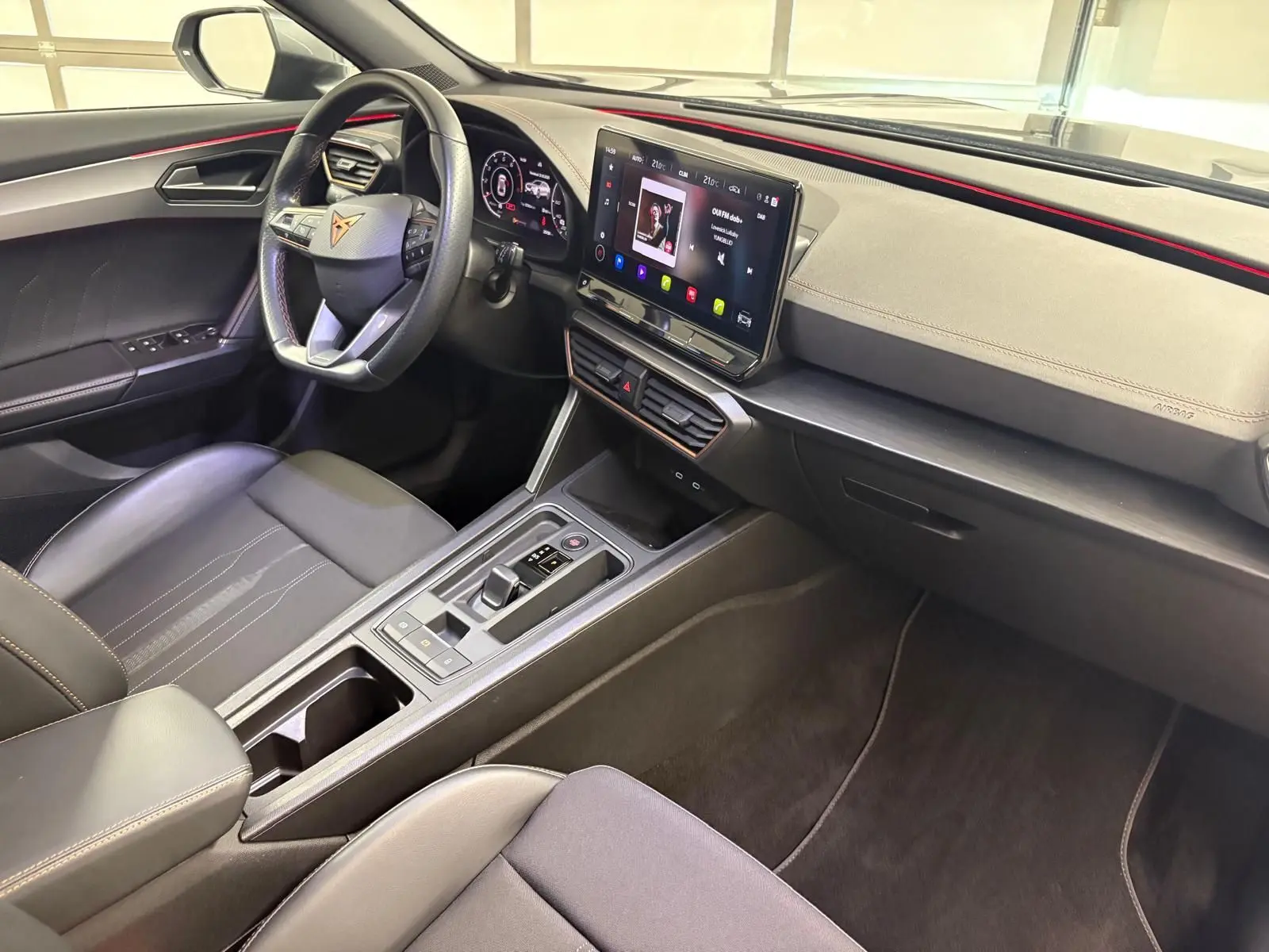 Intérieur avant droit du CUPRA Formentor 2023 avec tableau de bord noir, volant multifonction et écran tactile central.