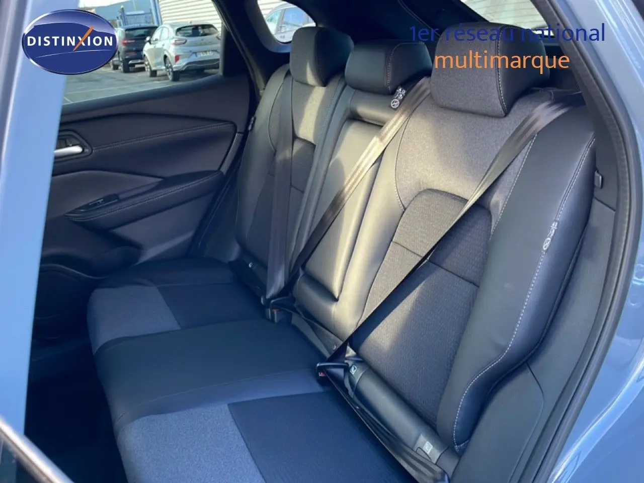 Vue intérieure côté droit montrant la banquette arrière en cuir et tissu noir du Nissan Qashqai gris argile métal 2025.