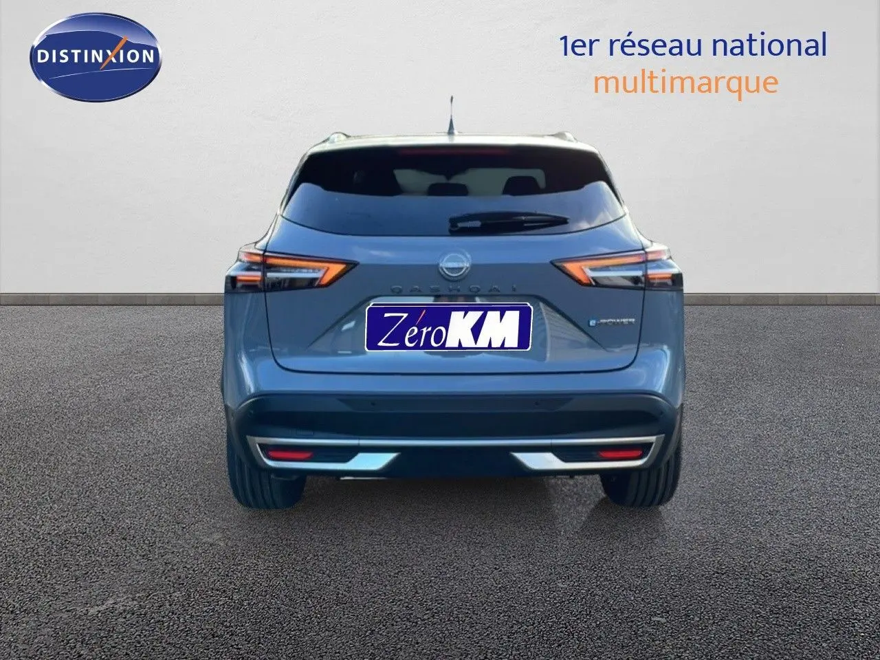 Vue arrière d'un Nissan Qashqai gris argile métal 2025 avec feux LED et hayon fermé sur fond neutre.