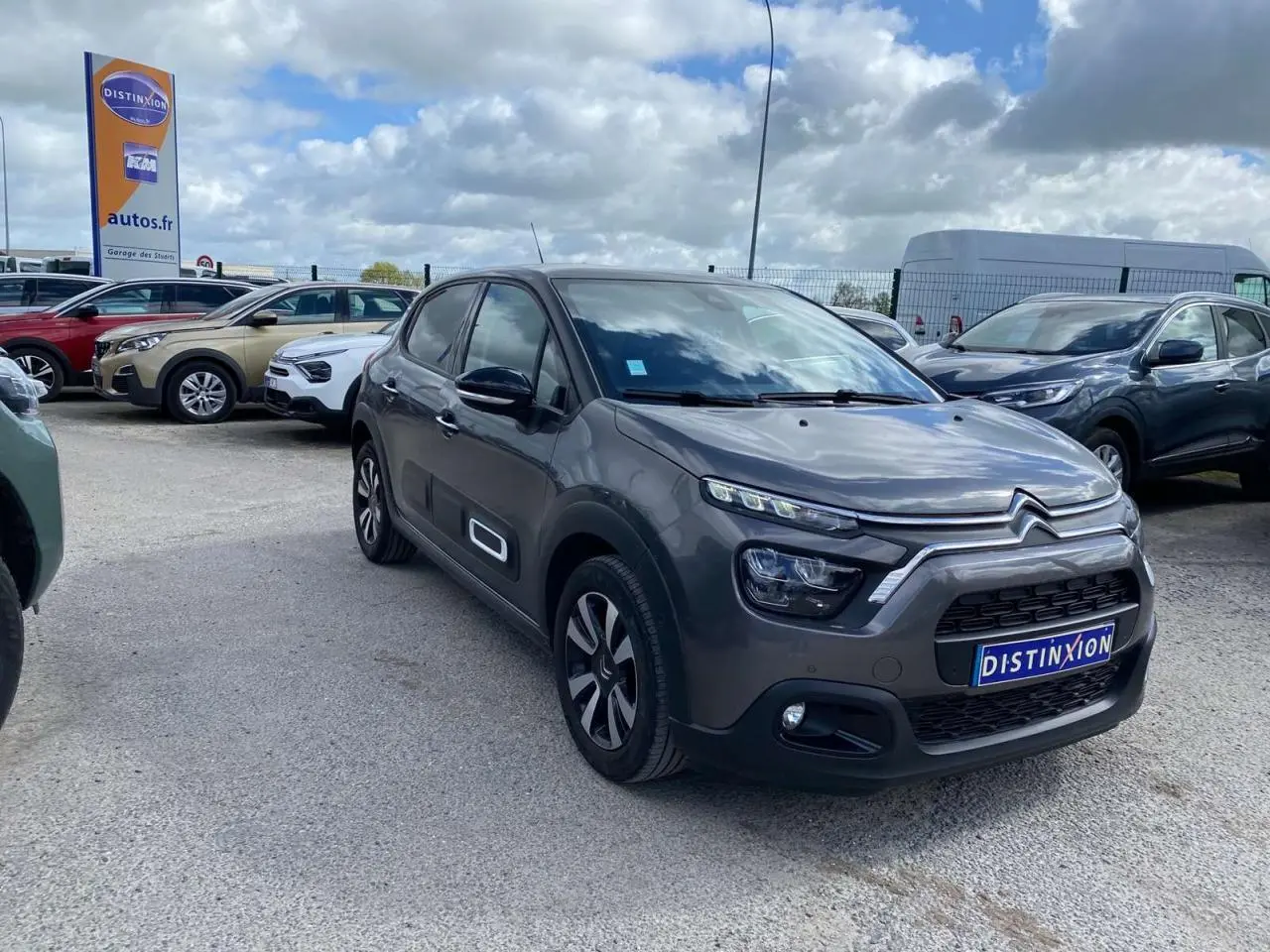 Citroën C3 gris platinium en 3/4 avant droit, avec toit bi-ton noir et jantes alliage diamantées visibles.