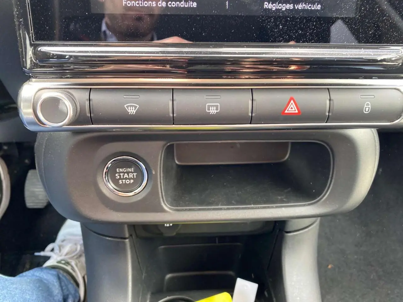 Vue rapprochée du bouton start/stop et des commandes de climatisation sur la console centrale de la Citroën C3 2021.