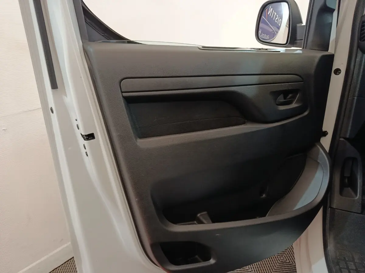 Vue intérieure côté gauche de la porte avant blanche du Peugeot Expert Fourgon avec panneau de porte noir et poignée intégrée.