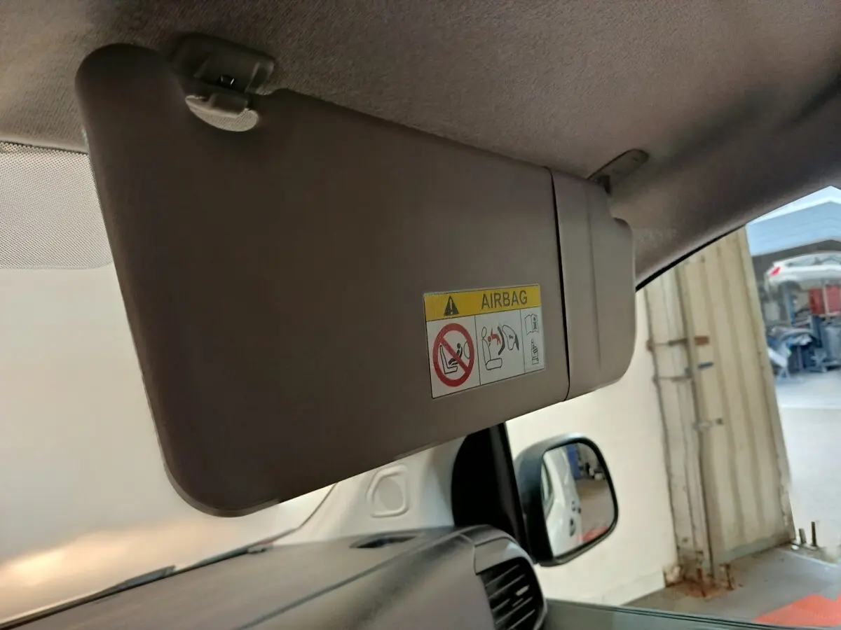 Pare-soleil côté conducteur beige avec étiquette airbag, vue intérieure avant droite du Peugeot Expert Fourgon blanc.