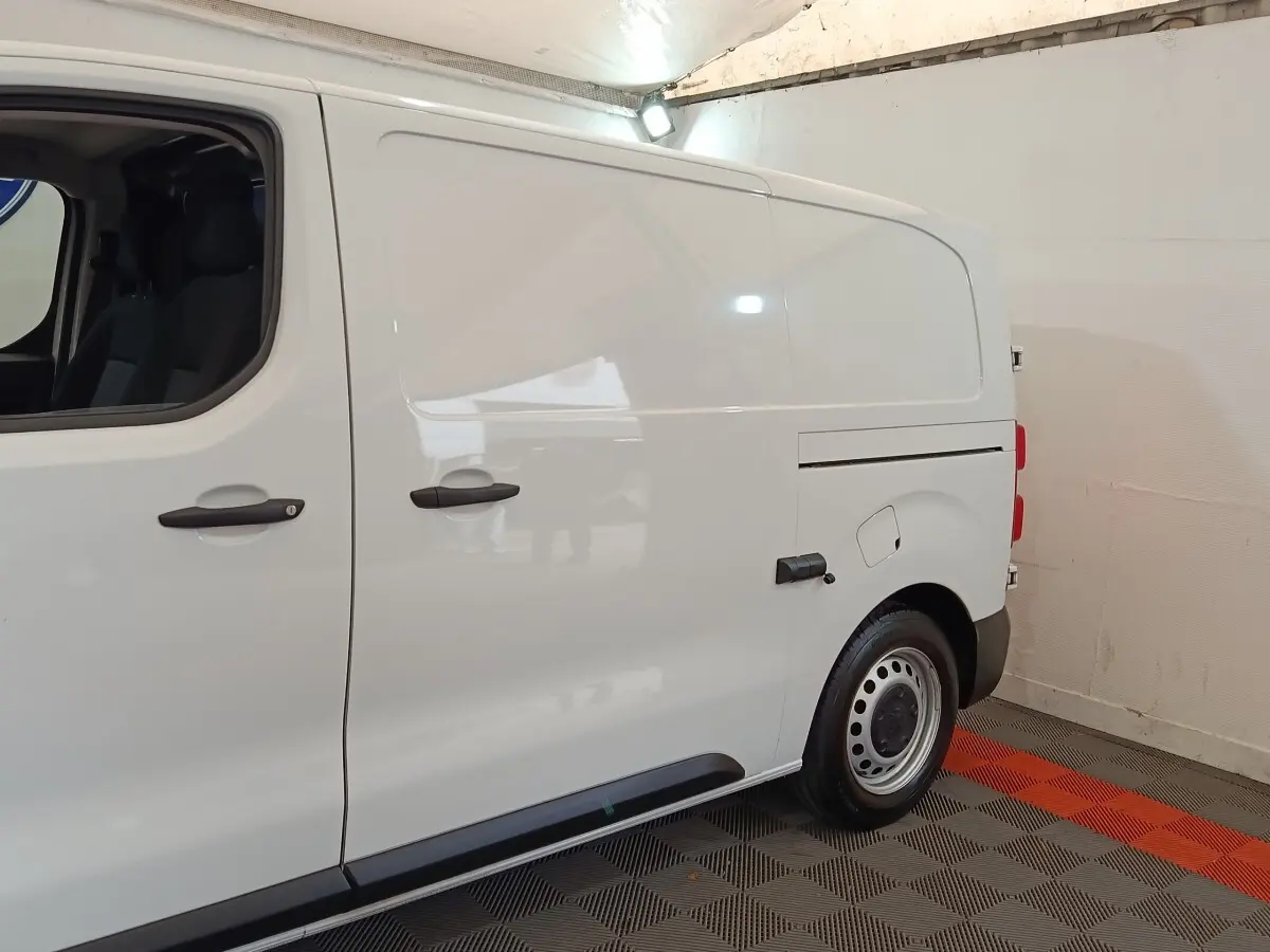Vue de profil côté droit d’un Peugeot Expert Fourgon blanc, avec portes latérales pleines et jantes acier.