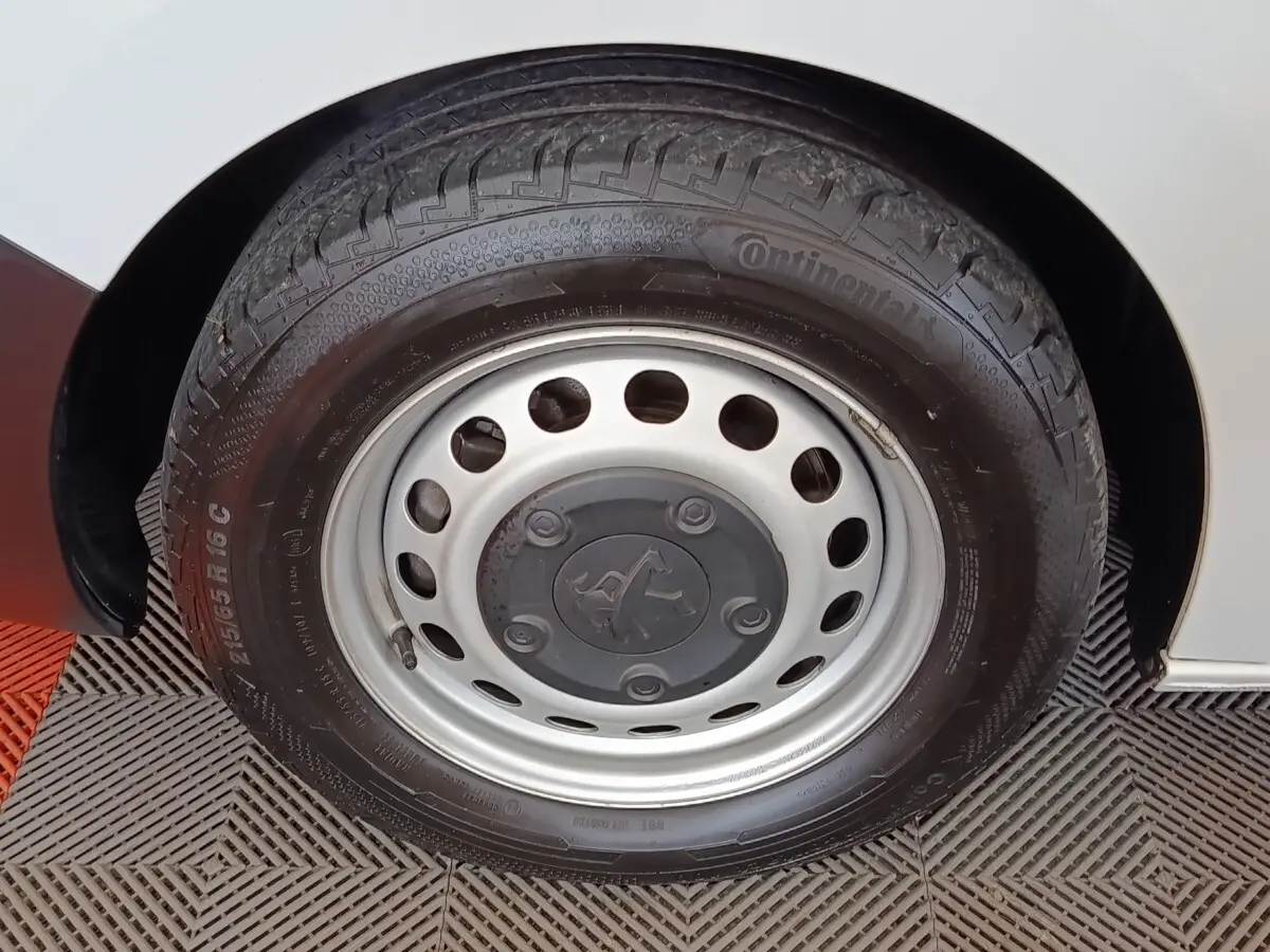 Gros plan sur la roue avant droite du Peugeot Expert Fourgon blanc, mettant en valeur la jante acier et le pneu Continental.