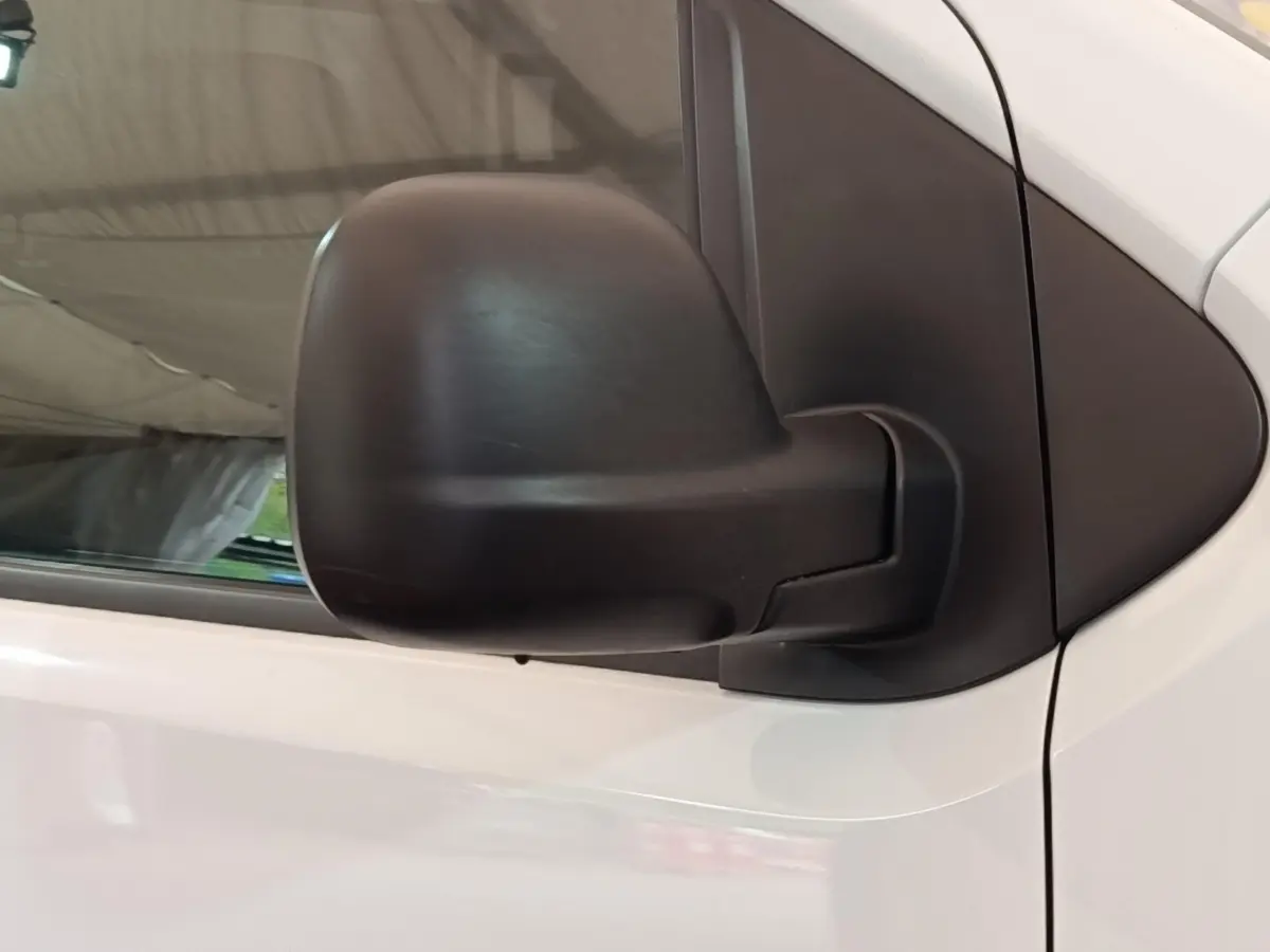 Rétroviseur noir en gros plan côté gauche du Peugeot Expert Fourgon blanc, vue rapprochée sur la porte avant.