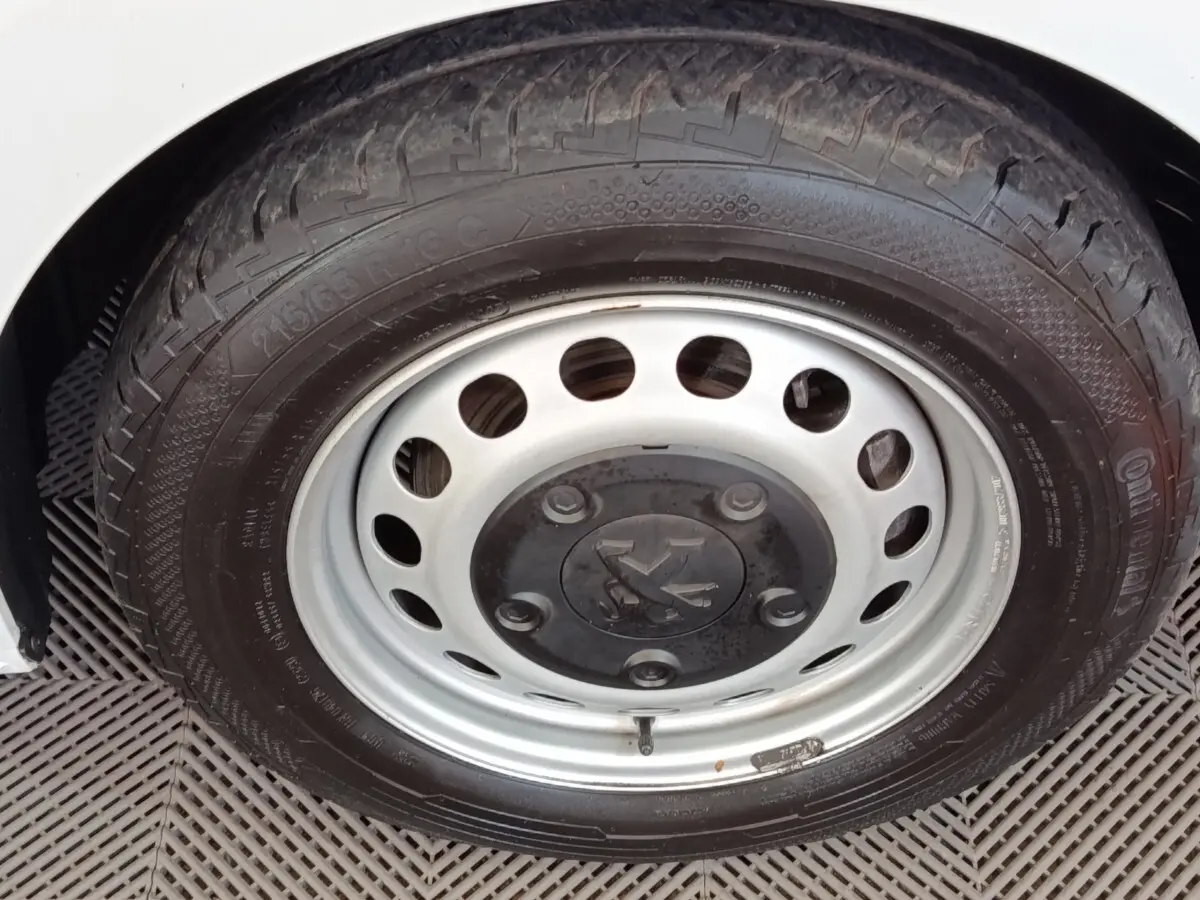 Gros plan sur la roue avant droite du Peugeot Expert Fourgon blanc, mettant en valeur la jante acier et le pneu Continental.