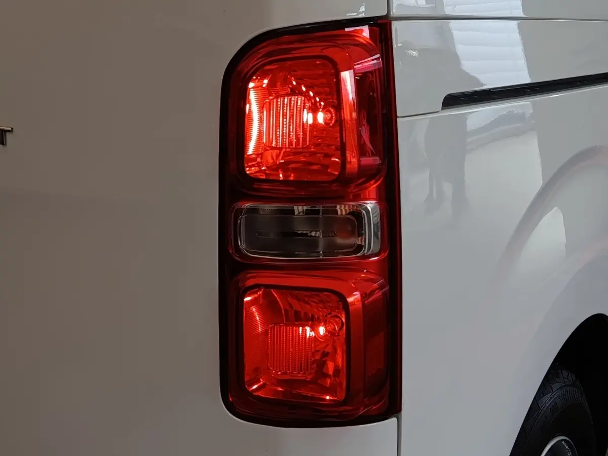 Gros plan sur le feu arrière droit rouge du Peugeot Expert Fourgon blanc, vue latérale arrière.
