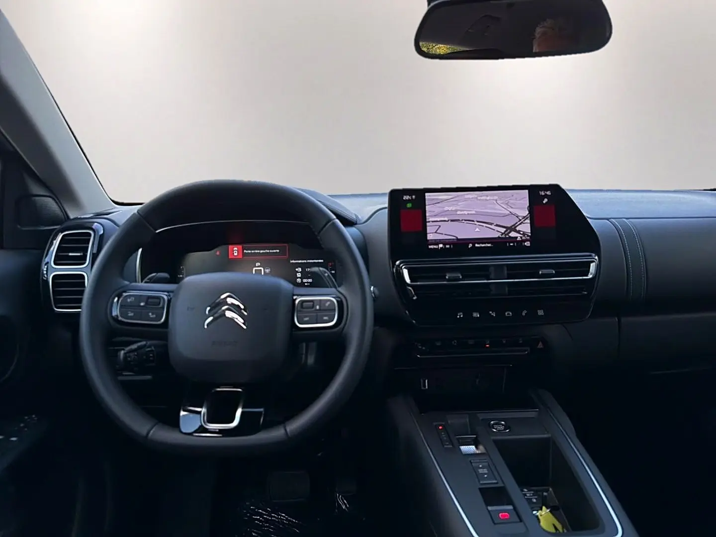 Vue frontale de l’intérieur du Citroën C5 Aircross 2025, volant cuir noir et écran tactile GPS au centre du tableau de bord.