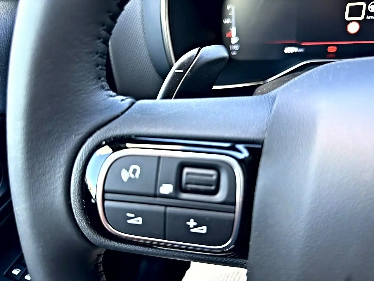 Gros plan sur les commandes gauche du volant cuir noir du Citroën C5 Aircross 2025, avec touches multifonctions.