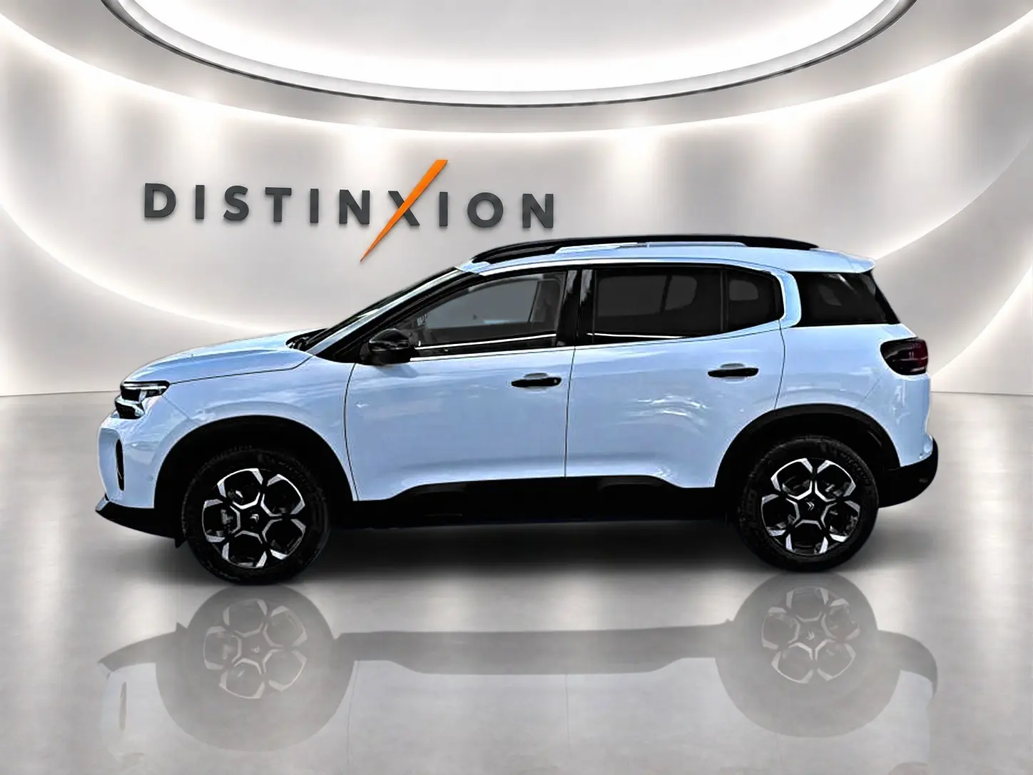 Profil droit du Citroën C5 Aircross blanc avec jantes noires et toit noir dans un showroom lumineux.