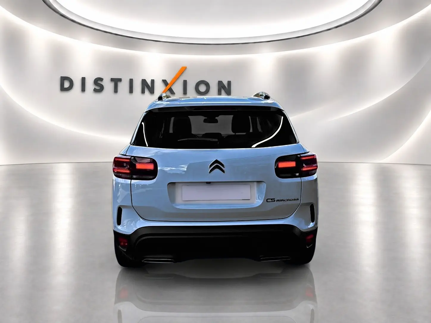 Vue arrière d'un Citroën C5 Aircross blanc 2025 dans un showroom lumineux avec logo Distinxion en arrière-plan.