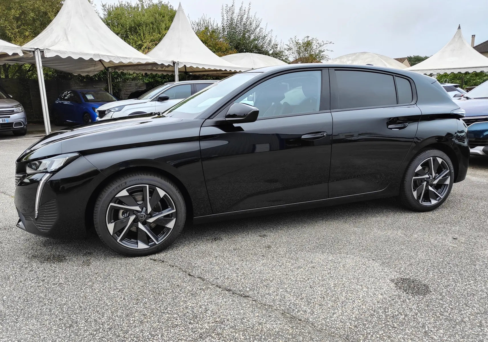Peugeot 308 PureTech 130 Allure Pack noire vue de profil côté gauche, avec jantes alliage bi-ton et vitres teintées.