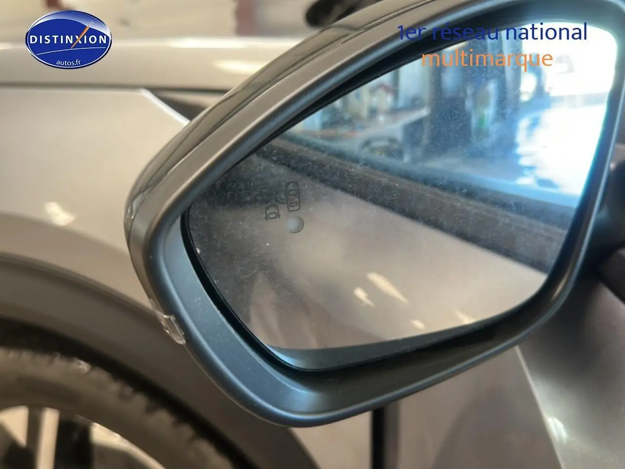 Rétroviseur extérieur côté gauche de la Peugeot 2008 gris artense, avec indicateur d'angle mort intégré.