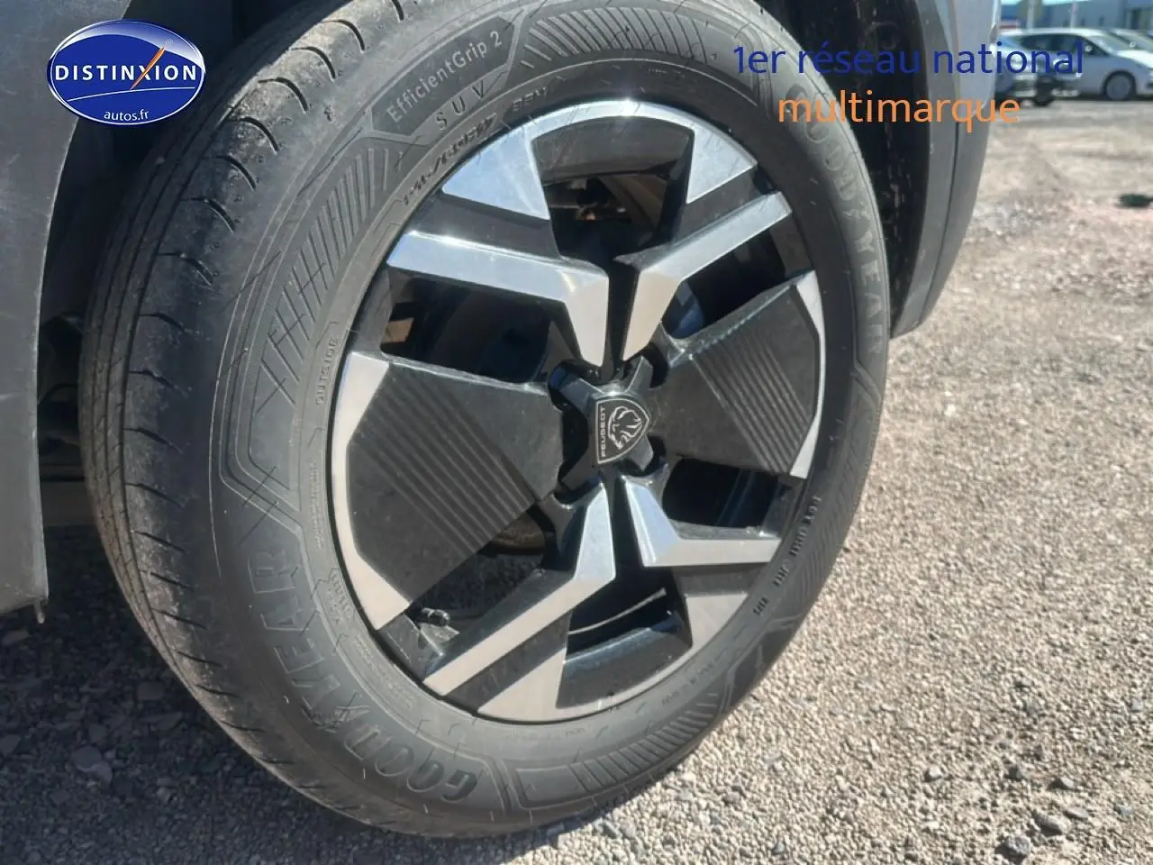 Vue rapprochée sur la roue avant gauche d’un Peugeot 2008 gris Artense, avec jante alu et pneu visible.