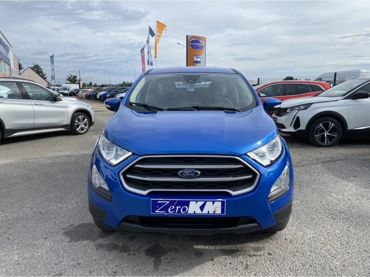 Vue de face d'un Ford EcoSport 2022 bleu Island avec calandre chromée et projecteurs antibrouillard visibles.
